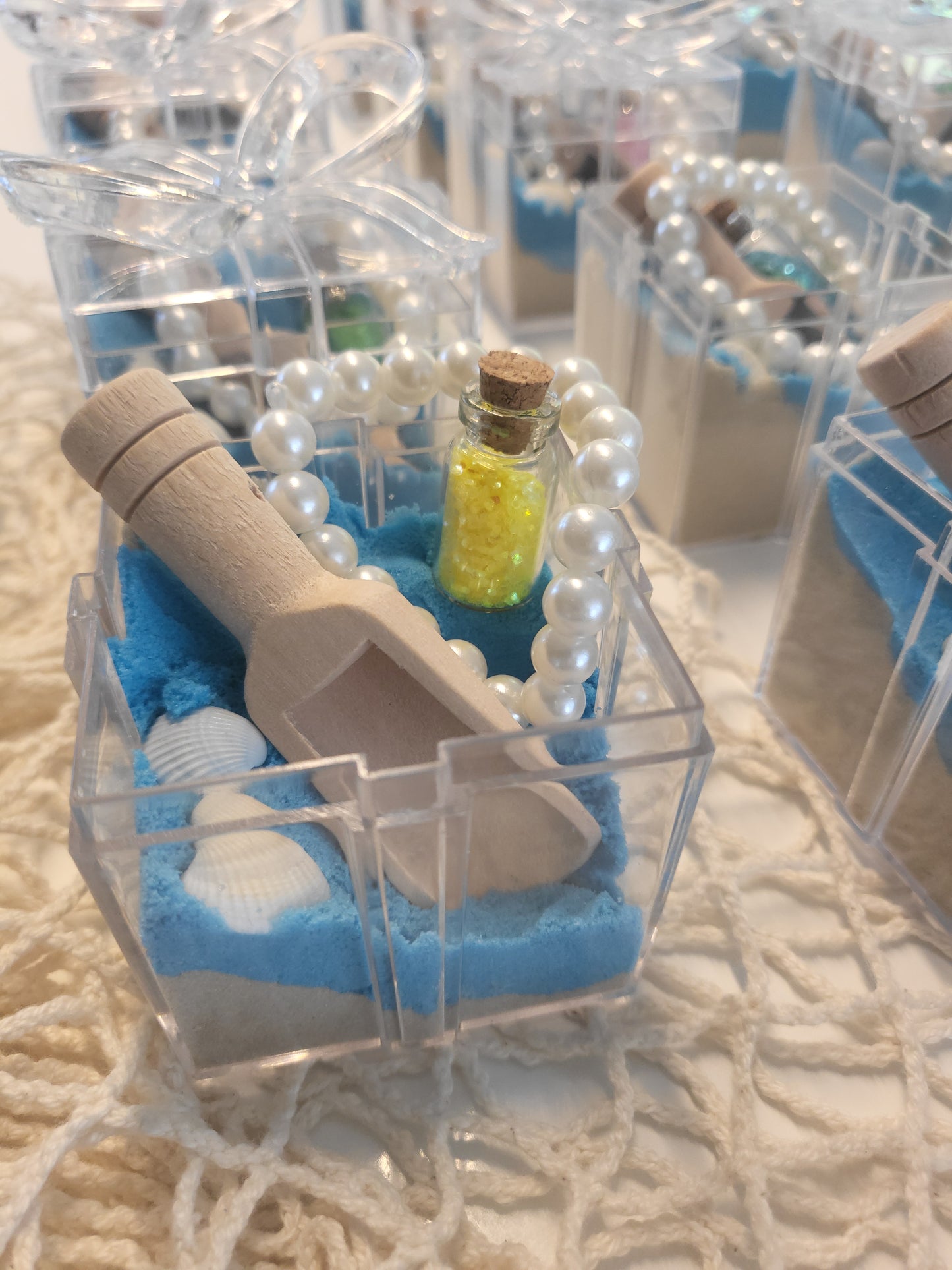 Mermaid under the sea party bag. Sensory kit. Tuff tray. Clear box,filled with half blue sand and clear kinetic sand, a scoop to play, seashells, glitter message in a bottle, and pearl treasure braclet